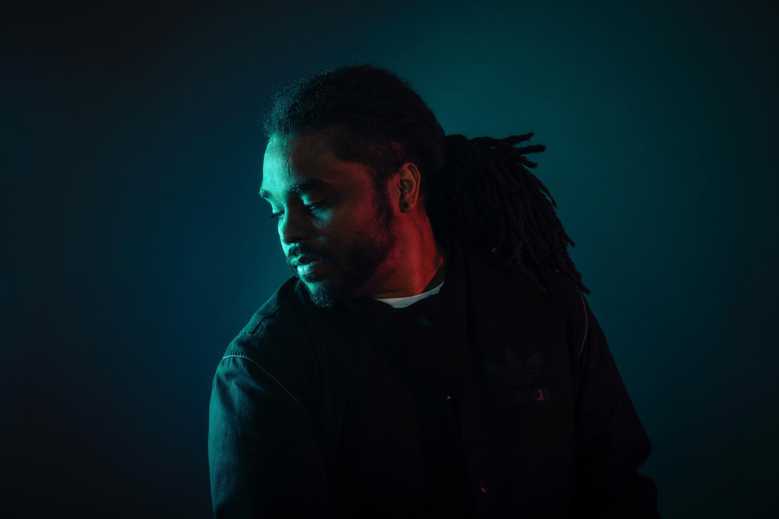 Celio Chomereau-Lamotte, alias AKUJI, compositeur et percussionniste, portrait de studio en lumière rouge et cyan